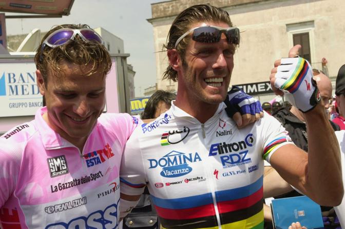 Siamo ancora al Giro 2003, foto ricordo a Matera, alla partenza della seconda tappa, tra Alessandro Petacchi (in maglia rosa) e Mario Cipollini, che veste l'iride